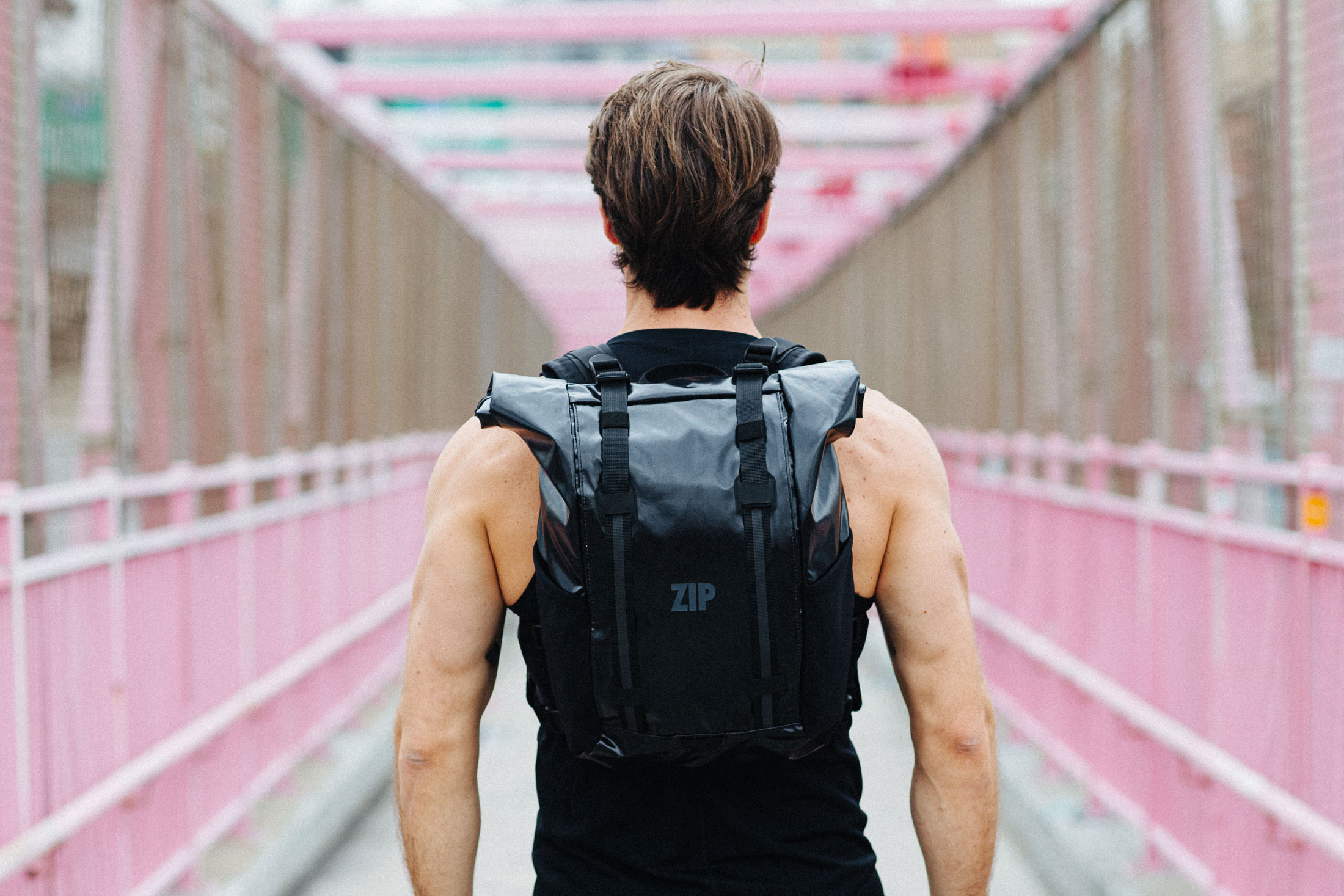 Commute Packを背負い、橋の遊歩道を歩く人物
